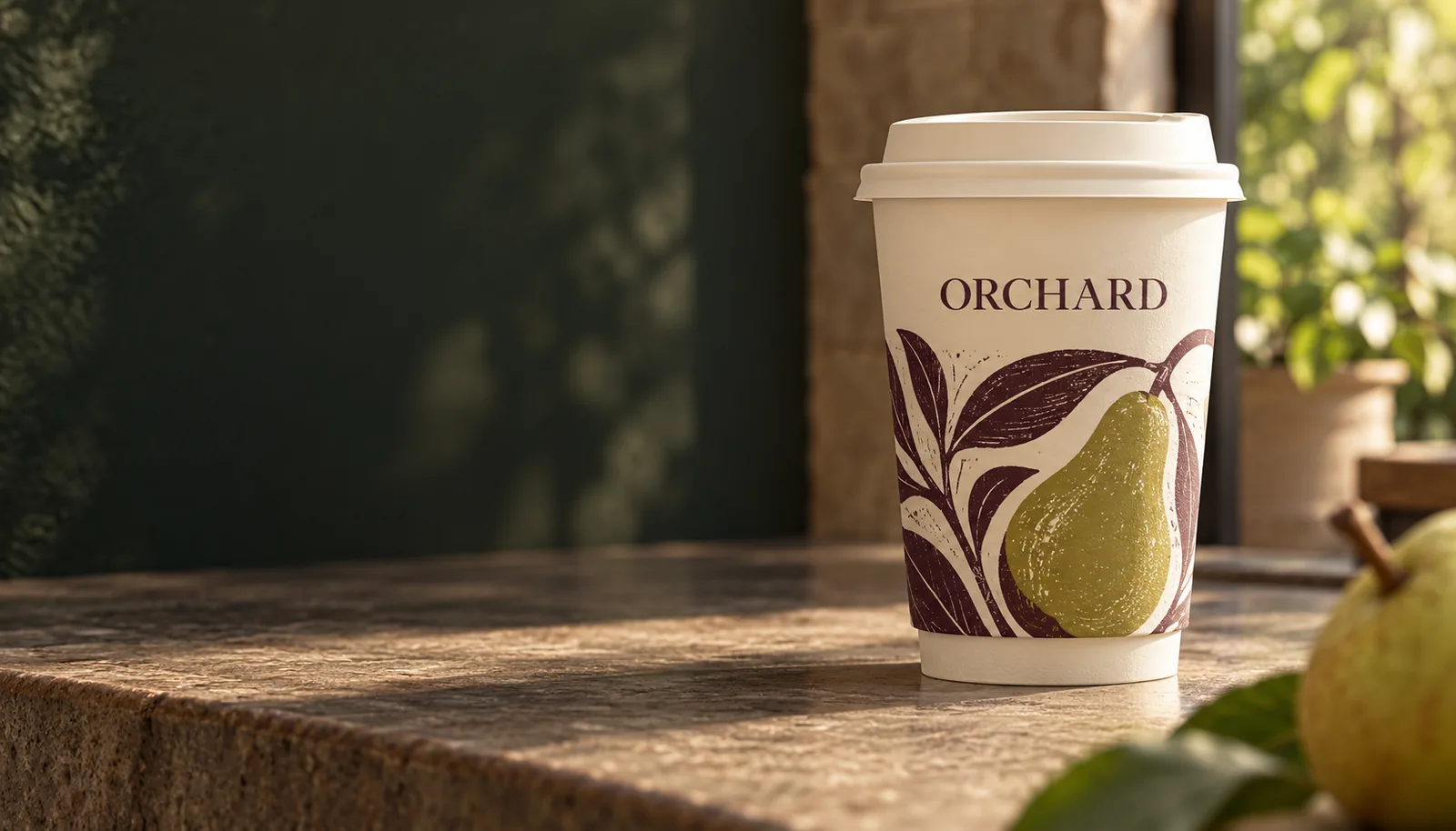 Original ORCHARD take out cup concept with pear artwork and an ivory sip lid on a cafe counter